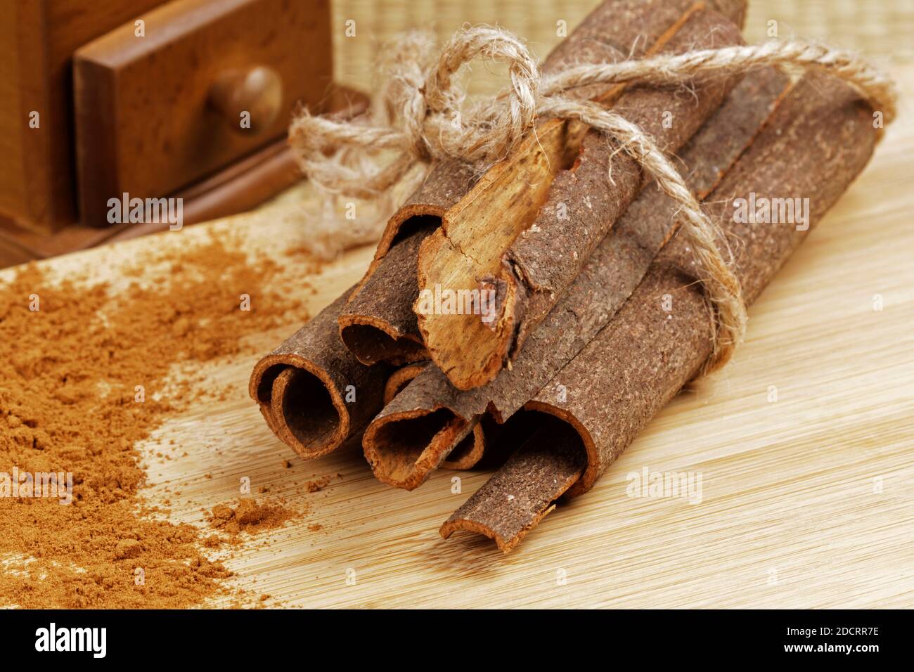 Delicious ground cinnamon and cinnamon bark on a wooden background Stock Photo