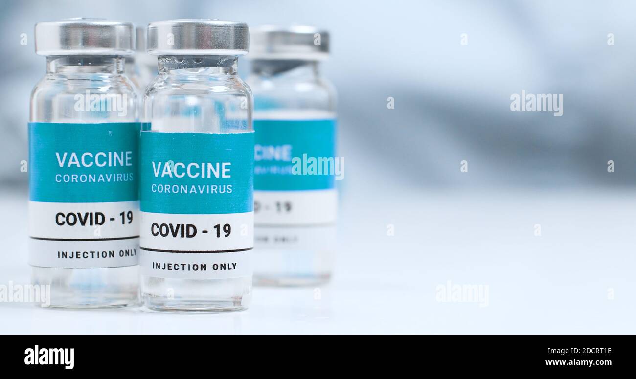 Coronovirus, covid-19 vaccination of the population. SARS-CoV-2 Coronavirus COVID-19 Vaccine Vials on a white laboratory table with copyspace. Stock Photo