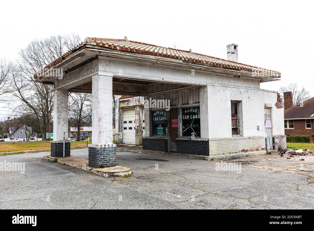 KINGS MTN, NC, USA-4 MARCH 2020: An abandoned old-style gas station building, last called Parker's Car Care, on a main street, with a for sale sign in Stock Photo