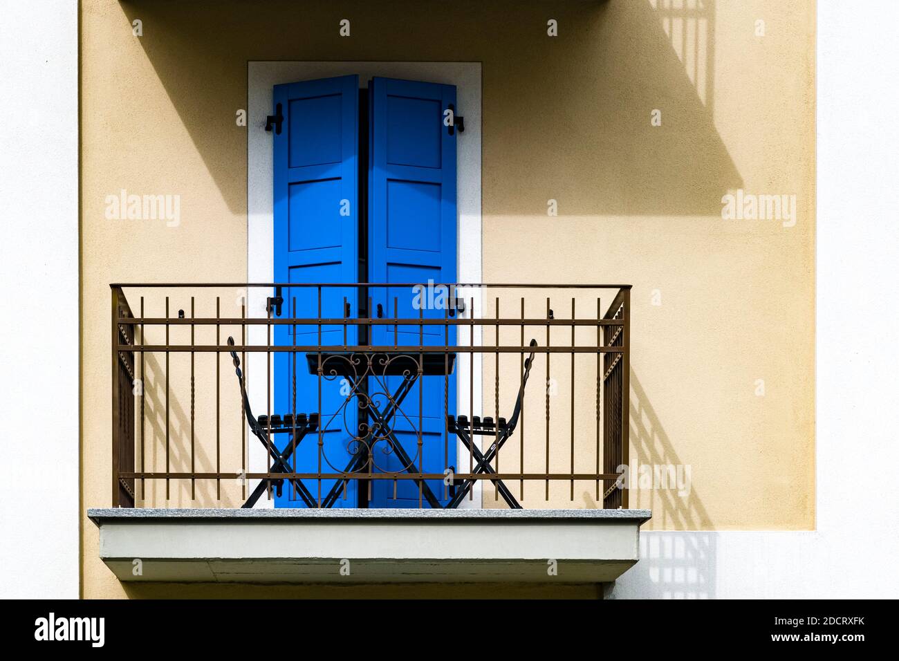 A balcony with blue doors at the facade of a house in the old part of town. Stock Photo