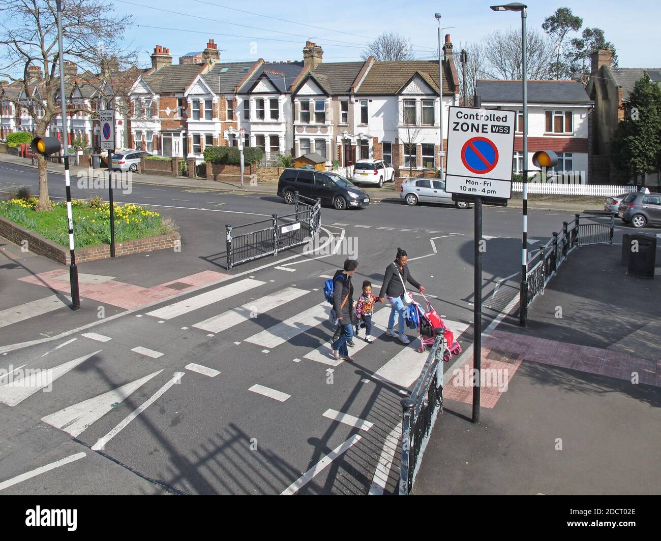 A family cross the road using a newly remodelled zebra crossing, Addison Rd, London. Part of Waltham Forest's Mini Holland scheme for safer streets. Stock Photo