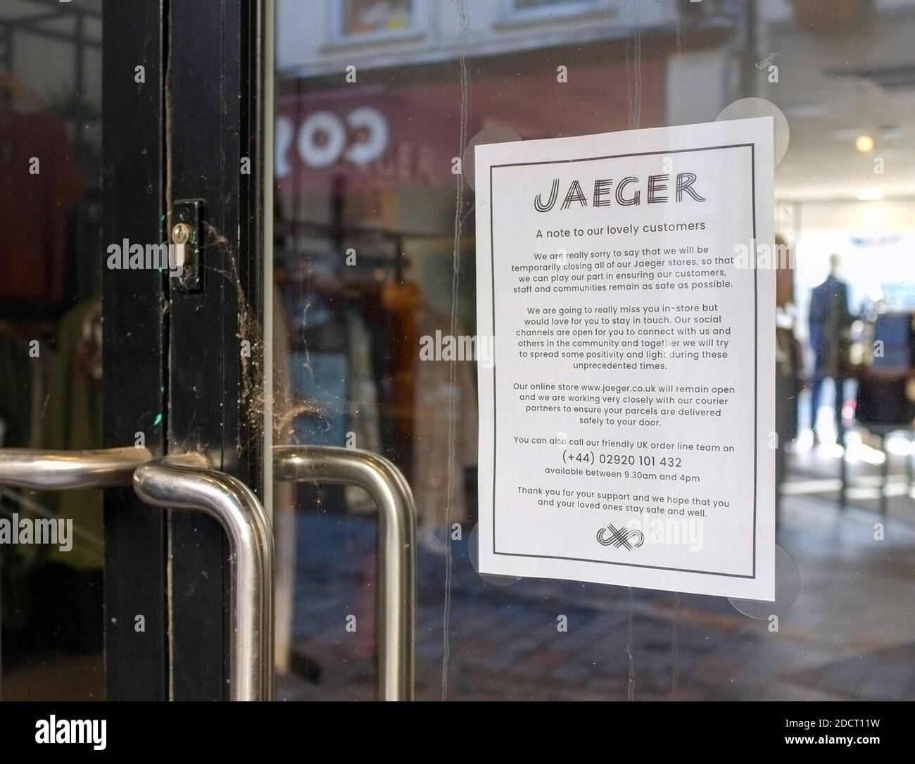 A Coronavirus closure notice on a dusty Jaeger shop front door in Butcher Row Salisbury UK. October 2020. Stock Photo
