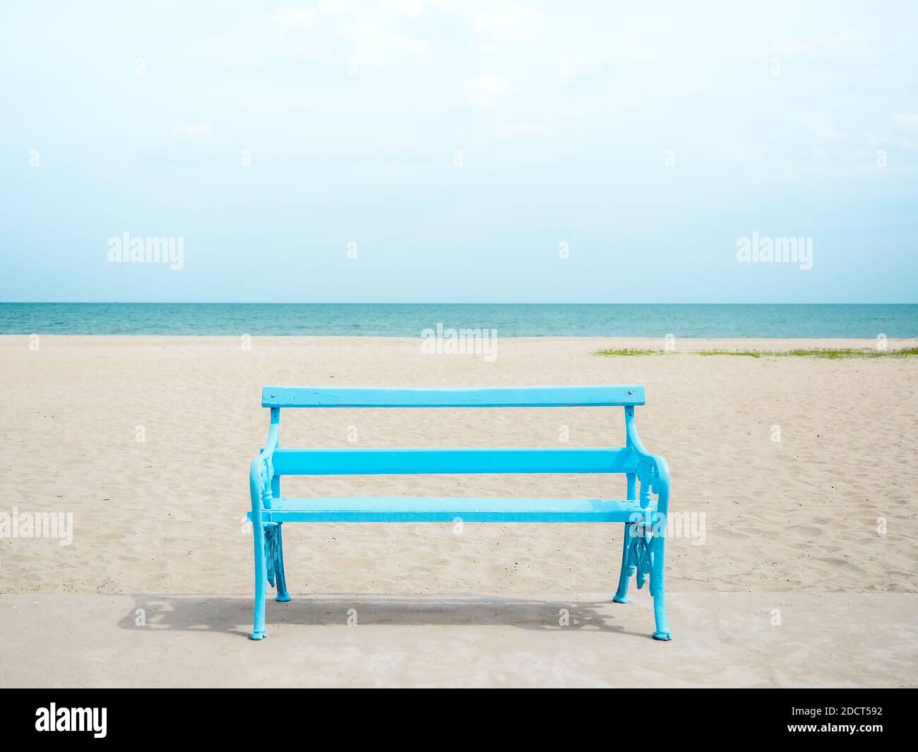 Empty light blue wooden bench on the beach on seascape, sea and blue