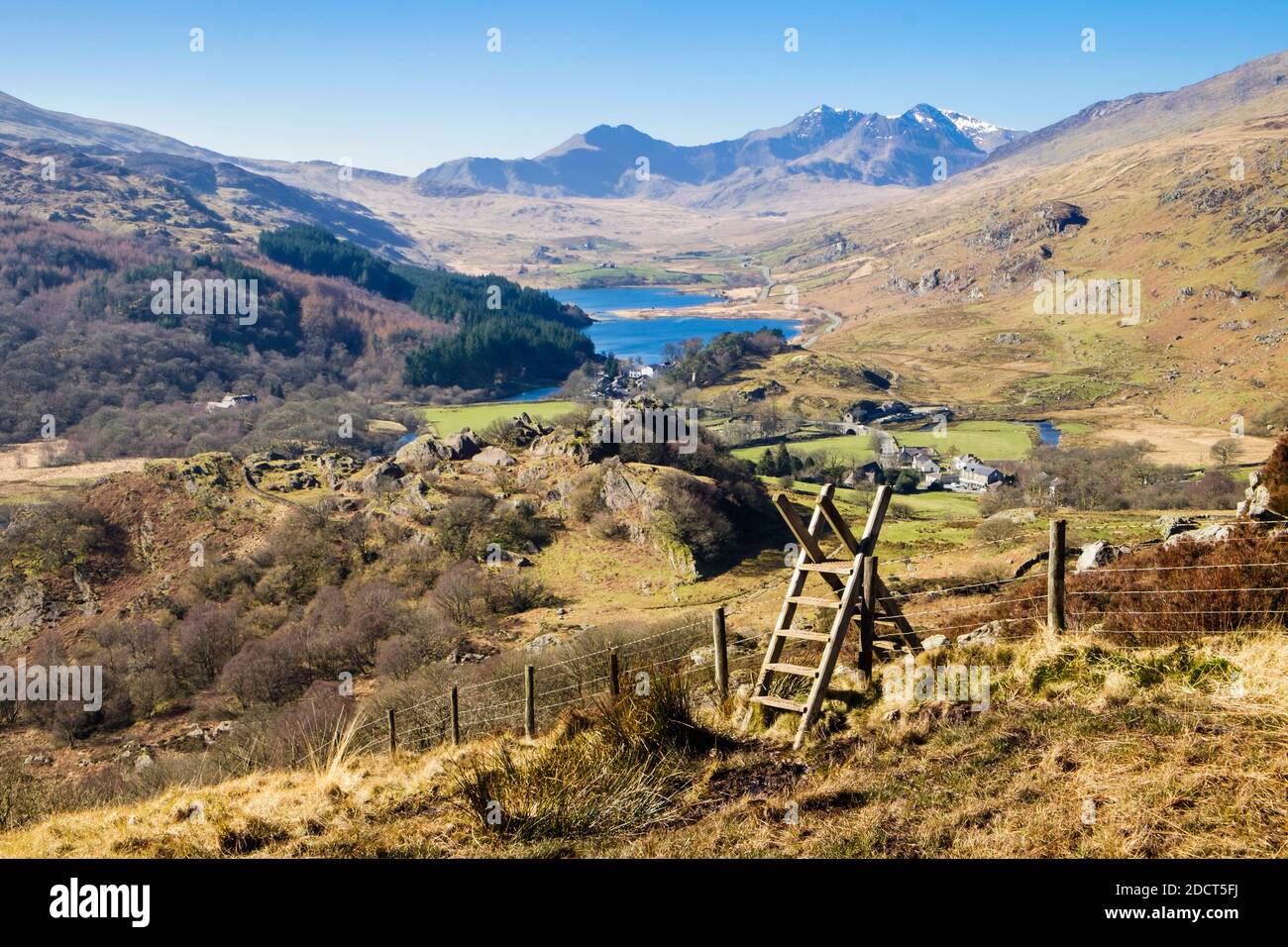 Ladder stile on footpath above Capel Curig with view to Nantygwryd and distant Snowdon Horseshoe in Snowdonia National Park. North Wales, UK, Britain Stock Photo