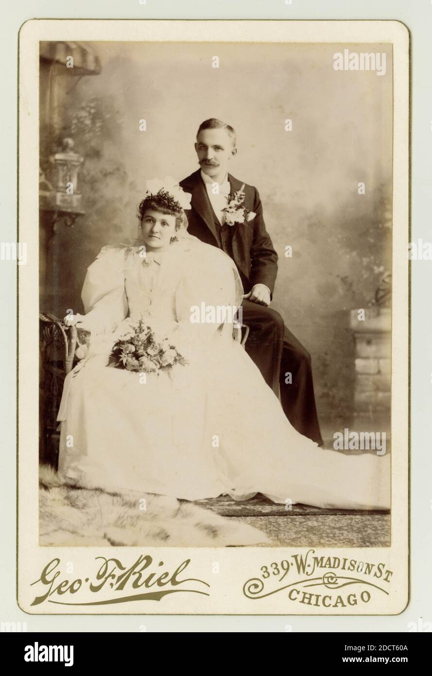 Original late 19th century, 1890s cabinet card studio portrait of Victorian  wedding. American bride and groom. Victorian brides and grooms. Americans.  The woman is wearing a white dress with big 'leg of