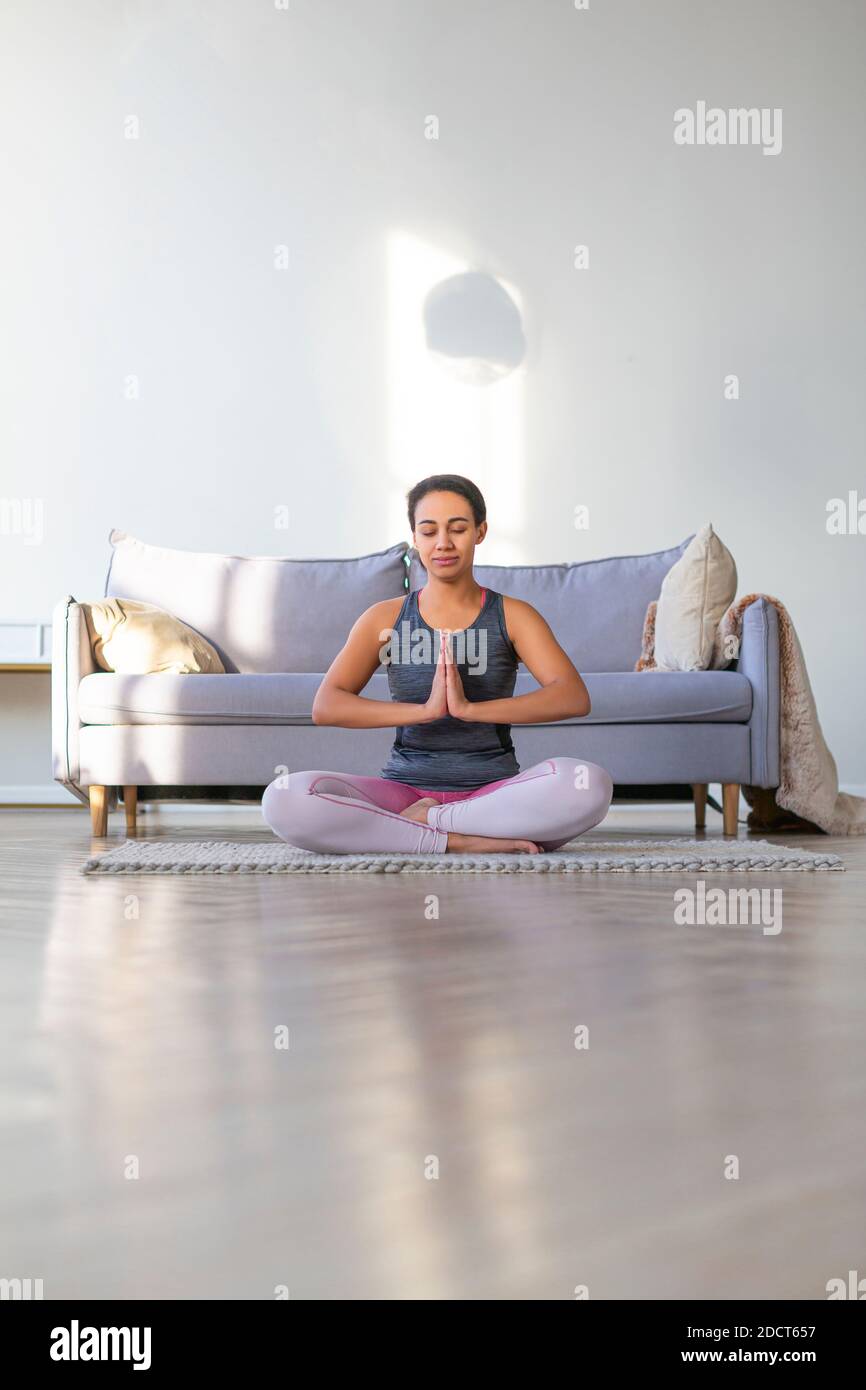 African American woman doing yoga at home. Prayer. Lotus position ...