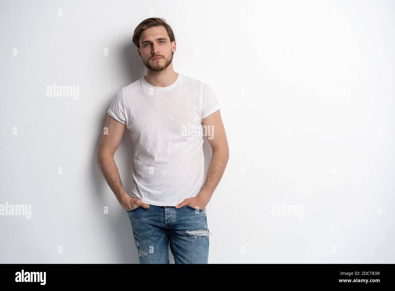 Portrait of a smart young man standing against white background Stock ...