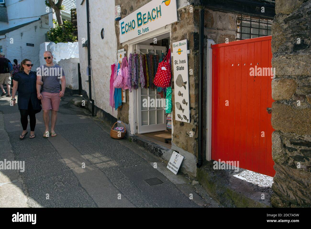 Young couple walking along narrow street in St Ives, Cornwall , United Kingdom Stock Photo