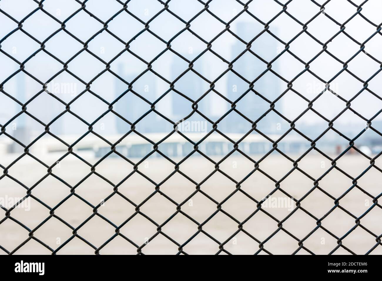 Steel wire mesh as a fence with blurred background of skylines Stock ...