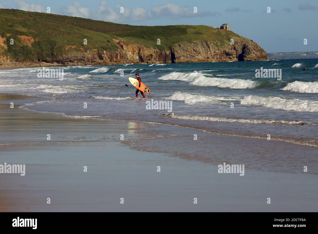 Surfer getting into the ocean at  Praa Sands Beach Cornwall, England, United Kingdom, Stock Photo