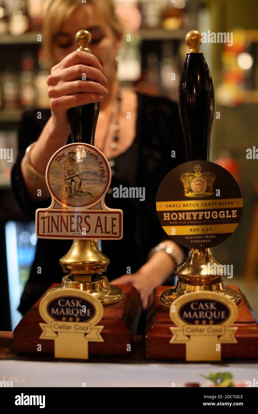 GREAT BRITAIN /Cornwall/ Real beers on handle in a Cornish pub. Woman working at the beer tap at Tinner's Arms pub in Zennor , Cornwall , UK Stock Photo