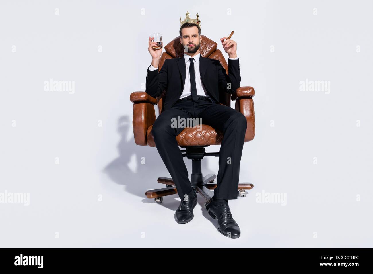 https://c8.alamy.com/comp/2DCTHFC/full-body-low-below-angle-view-photo-of-handsome-business-guy-sit-chair-hold-rum-glass-cuban-cigar-chief-wear-crown-black-blazer-pants-tie-shirt-shoes-2DCTHFC.jpg