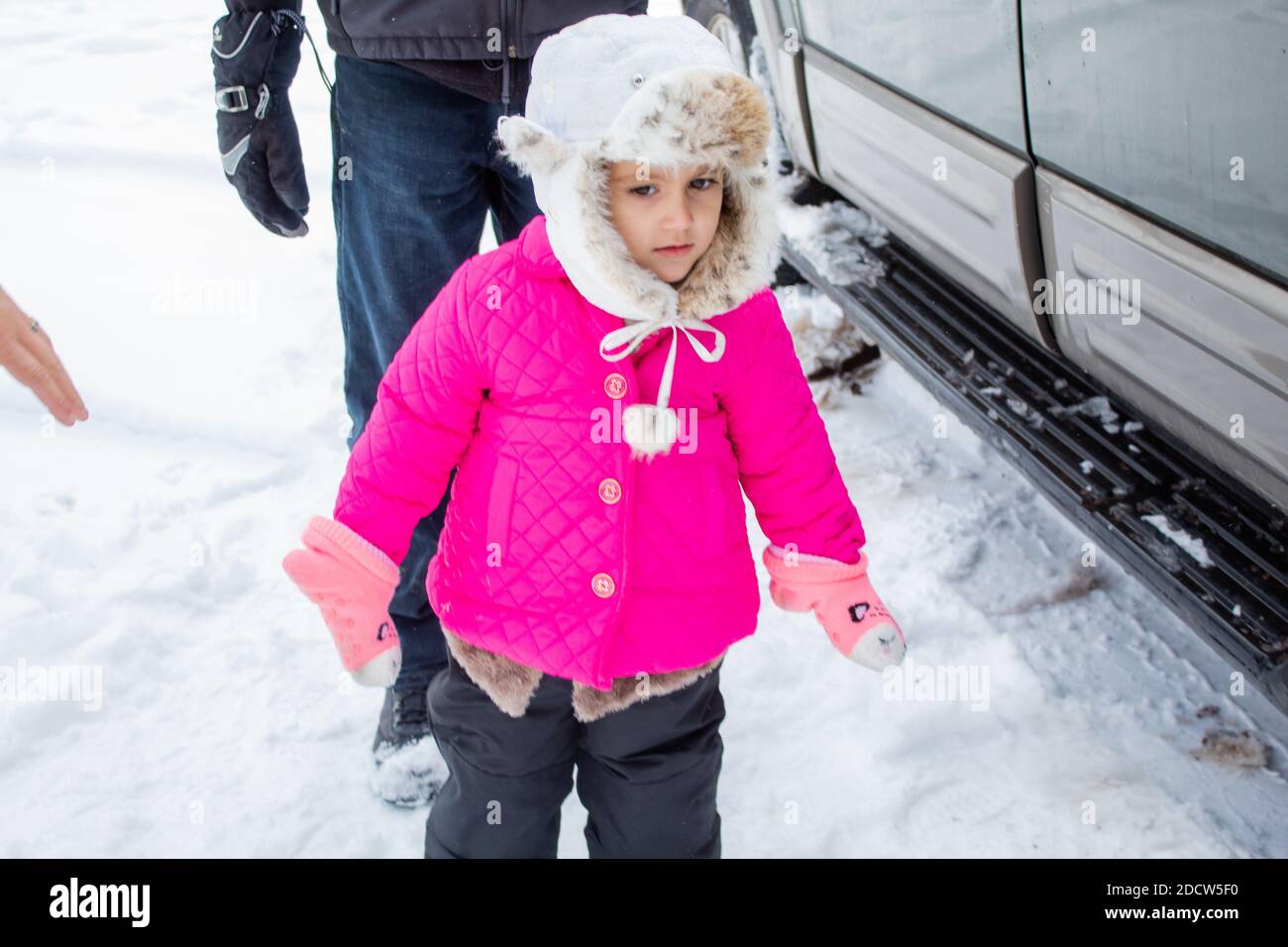Concerned little girl wearing a pink coat in snowy forest Stock Photo ...