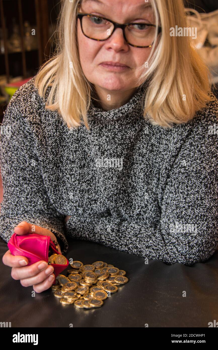 Woman with a pile of £1 coins. Stock Photo