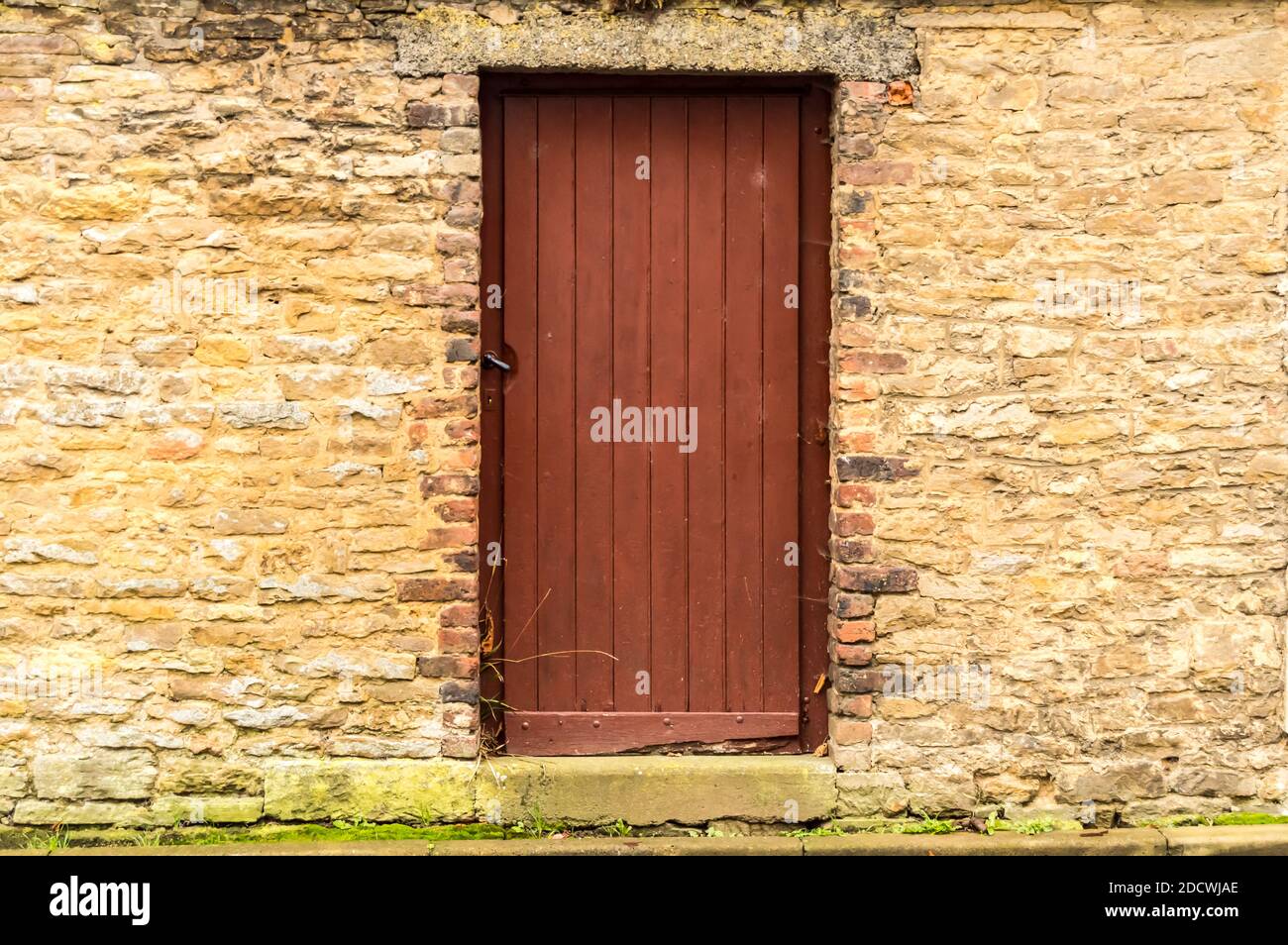 Old wooden door in the stone castle wall. Virton, Belgium Stock Photo