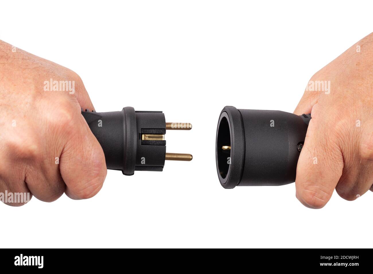 Two parts of an electrical plug in hands in the moment of connecting disconnecting Stock Photo