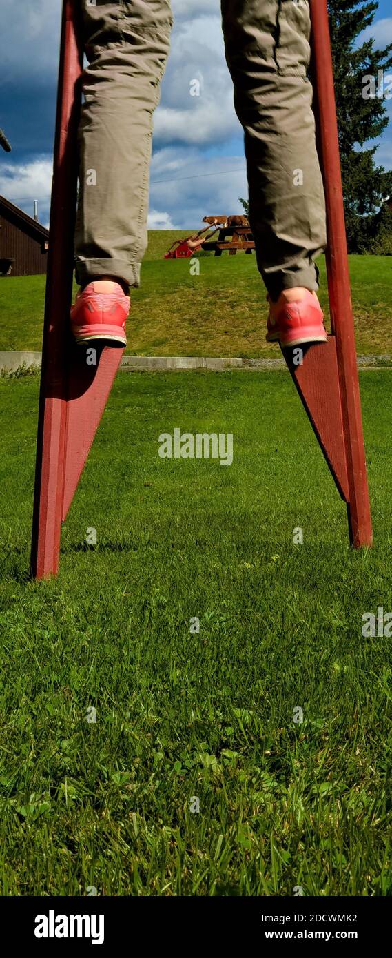 Person walking on traditional stilts in a park Stock Photo Alamy