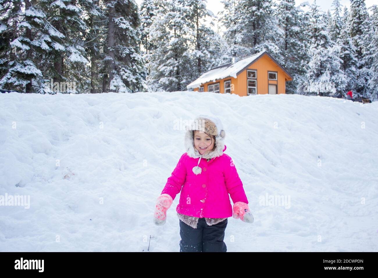 Happy little girl wearing a pink coat in snowy forest Stock Photo - Alamy