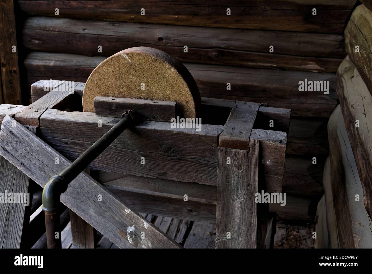 Antique grinding stone in wood, iron and rock, made for sharpening knives and other metal tools. Stock Photo