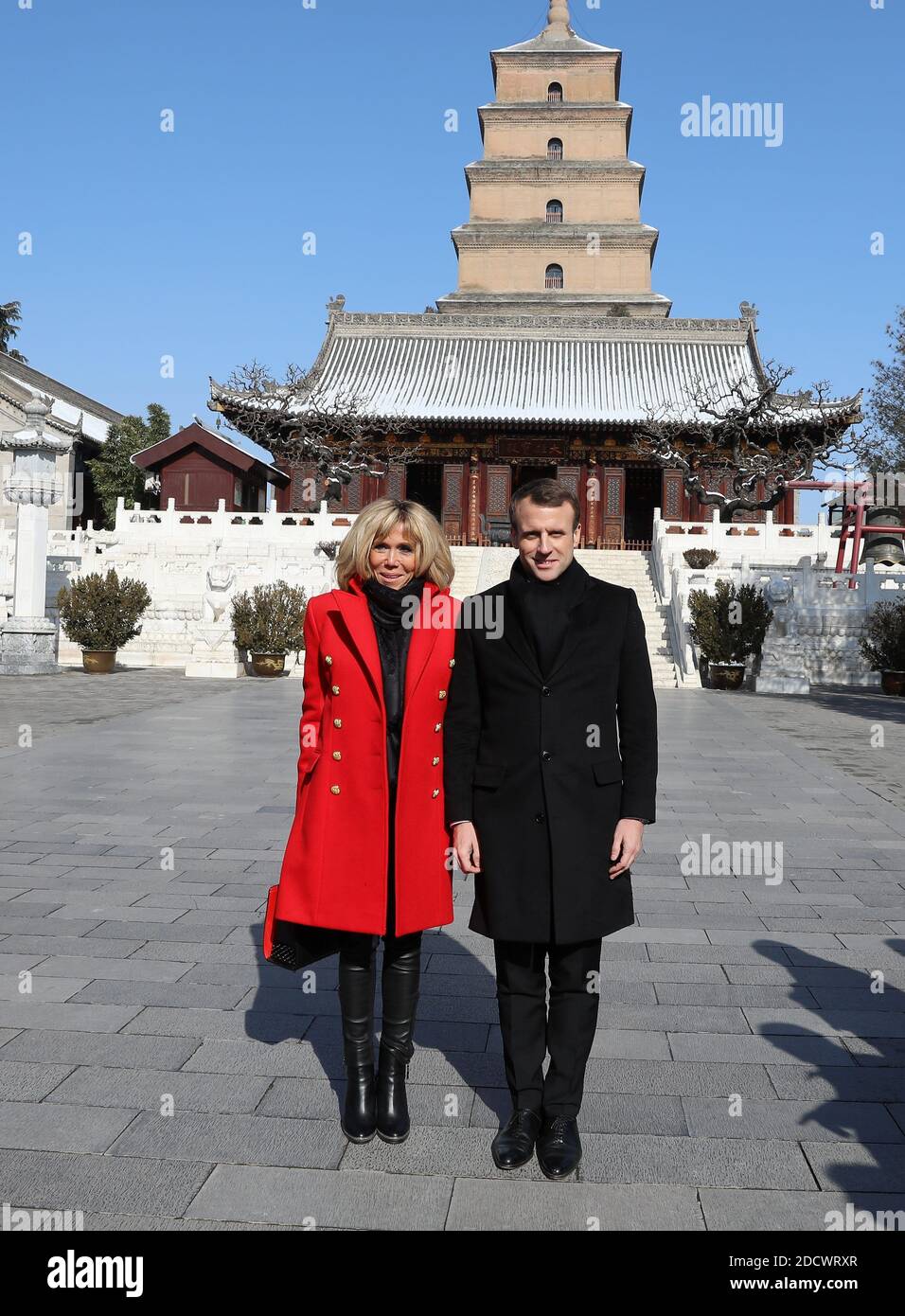 French President Emmanuel Macron and his wife Brigitte Macron listen to