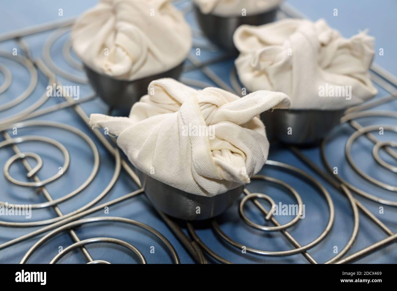 Christmas puddings, small individual servings wrapped in cotton ready to steam on Christmas Day Stock Photo