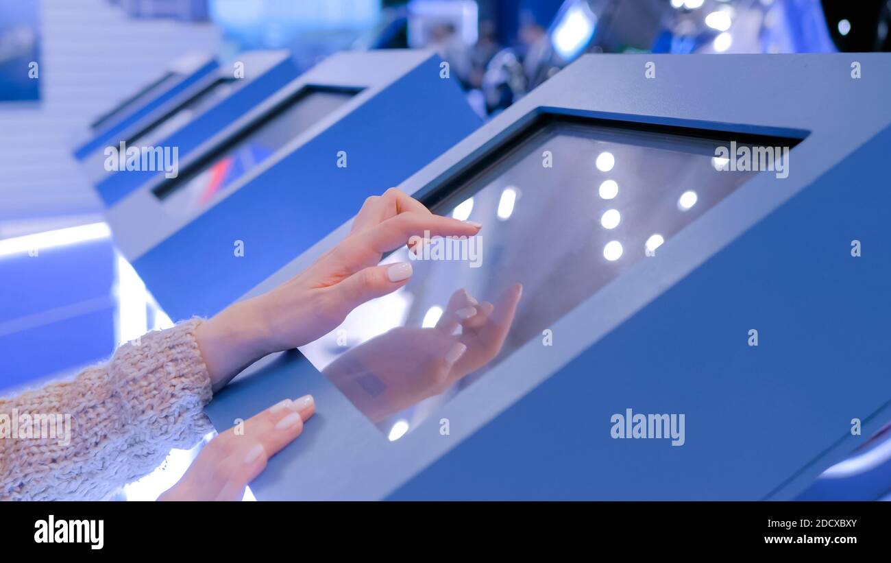 Woman using interactive touchscreen display at technology exhibition Stock Photo