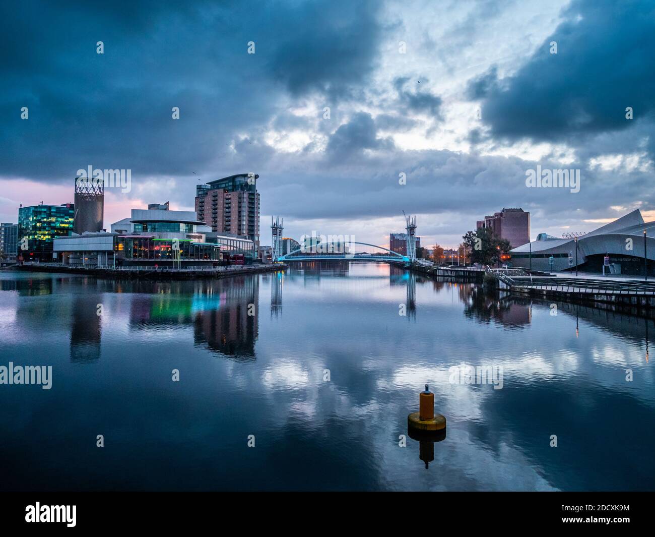 The building at Salford Quays and Media city reflecting in the water at sunrise Stock Photo