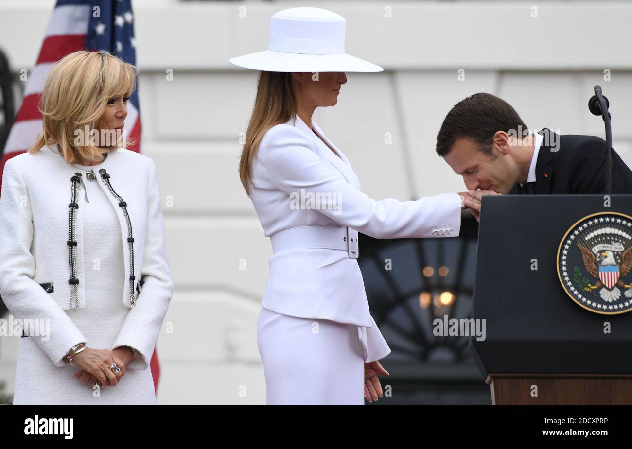 French President Emmanuel Macron kisses the hand of U.S first lady Melania  Trump as Brigitte Macron and looks on during a state arrival ceremony at  the White House April 24, 2018 in