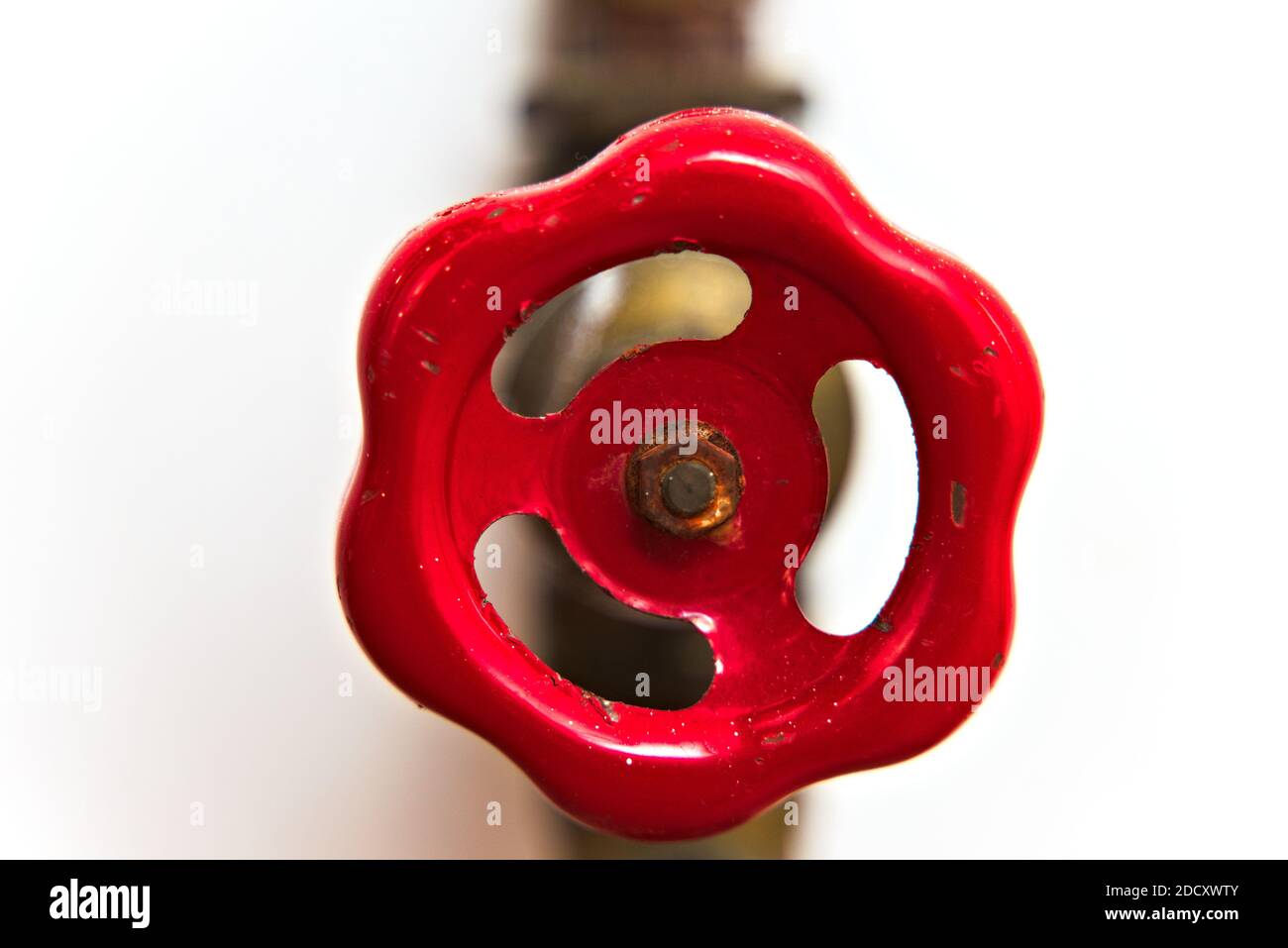 Old red valve on water pipes isolated on white. Stock Photo