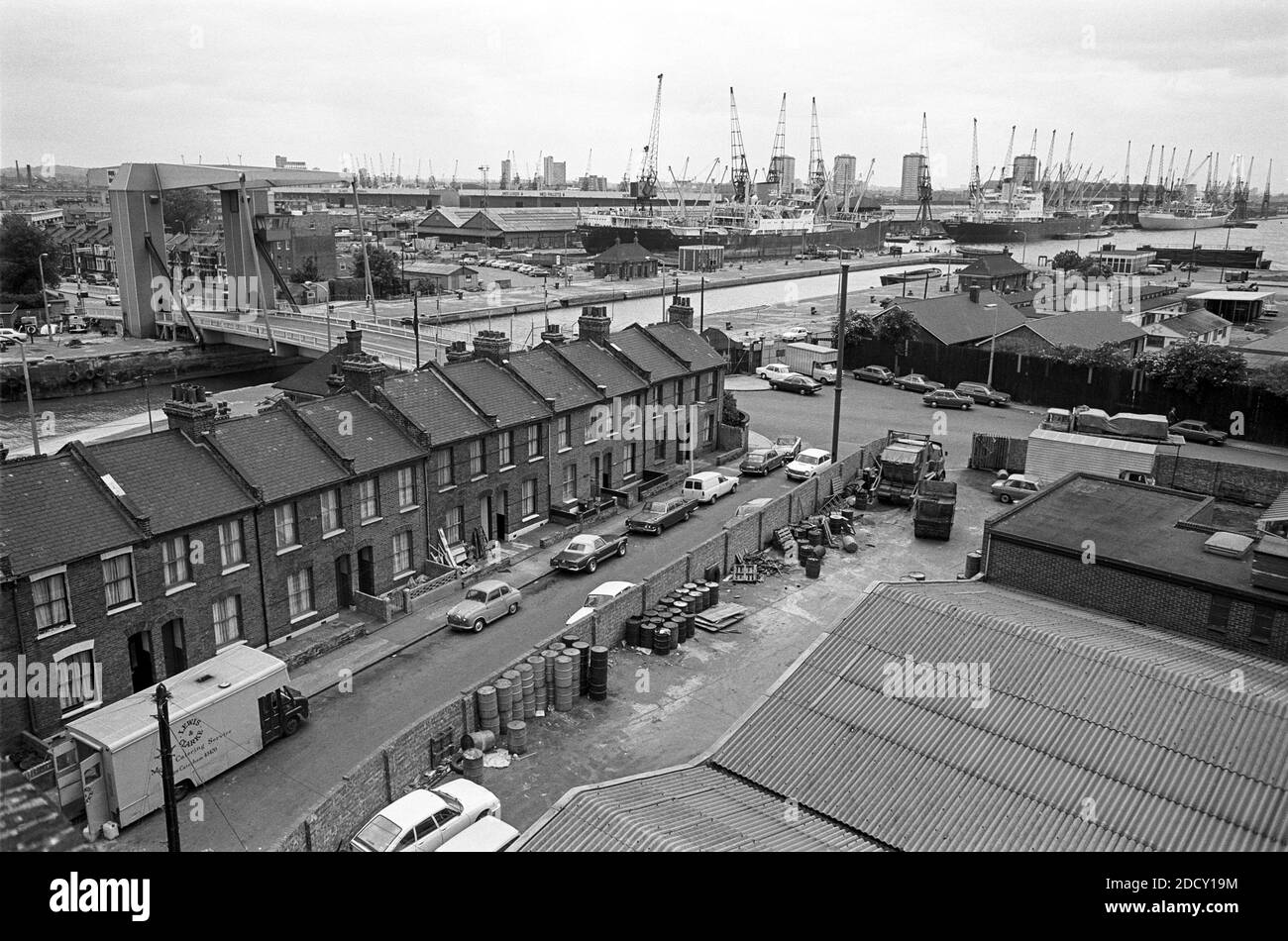 UK, London, Docklands, Isle of Dogs, Coldharbour, 1974. View to Main or south West India Dock over Preston's Rd from a disused warehouse on Coldharbour - near to The Gun pub. Terraced housing still exists, as does the Blue (lifting) Bridge. The warehouse is now demolished and new housing built on corner Horatio Place & Coldharbour. Stock Photo