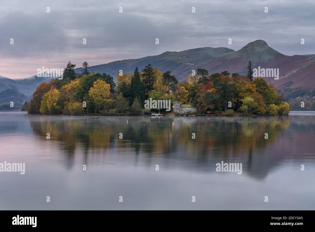Autumn trees on a cloudy morning at Derwentwater in the Lake District. Stock Photo