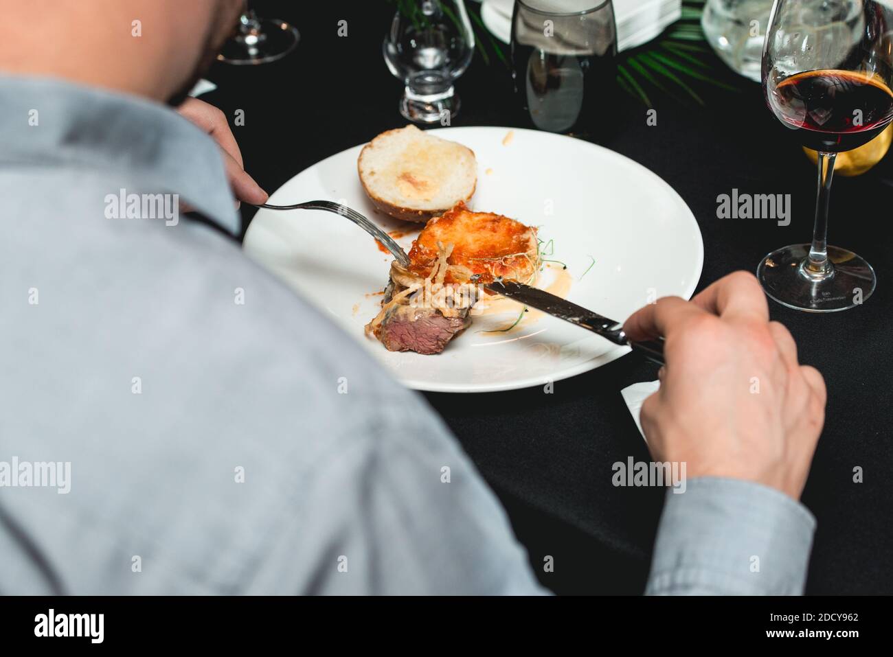 man in a fine dining restaurant eat fast food with knife and fork, closeup Stock Photo Alamy