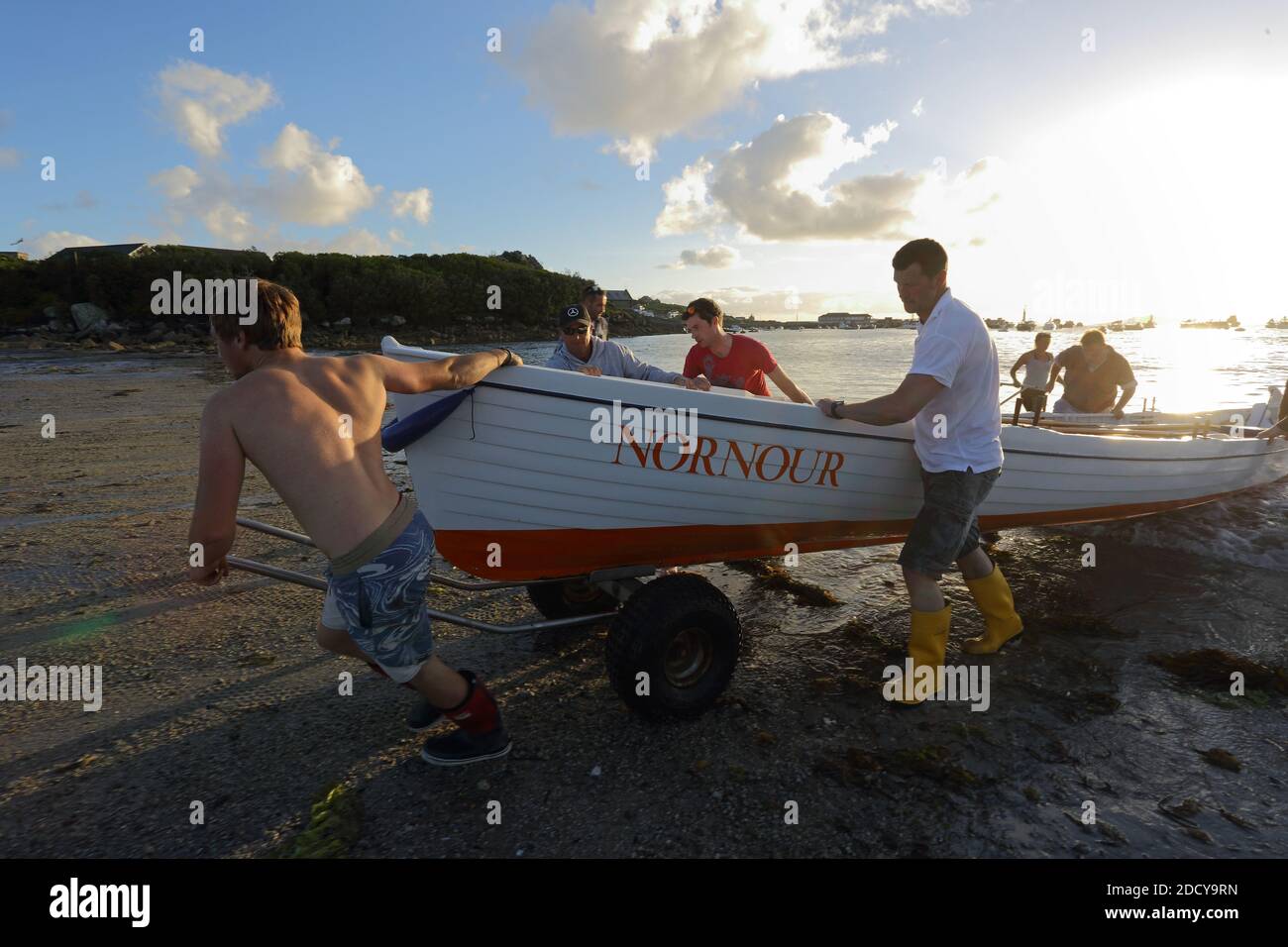 St Mary’s Gig crew pull the boat ashore after the race .  Isles of Scilly, Cornwall UK. Stock Photo