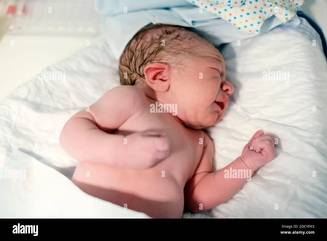 Newborn baby boy waiting for being dressed after birth Stock Photo