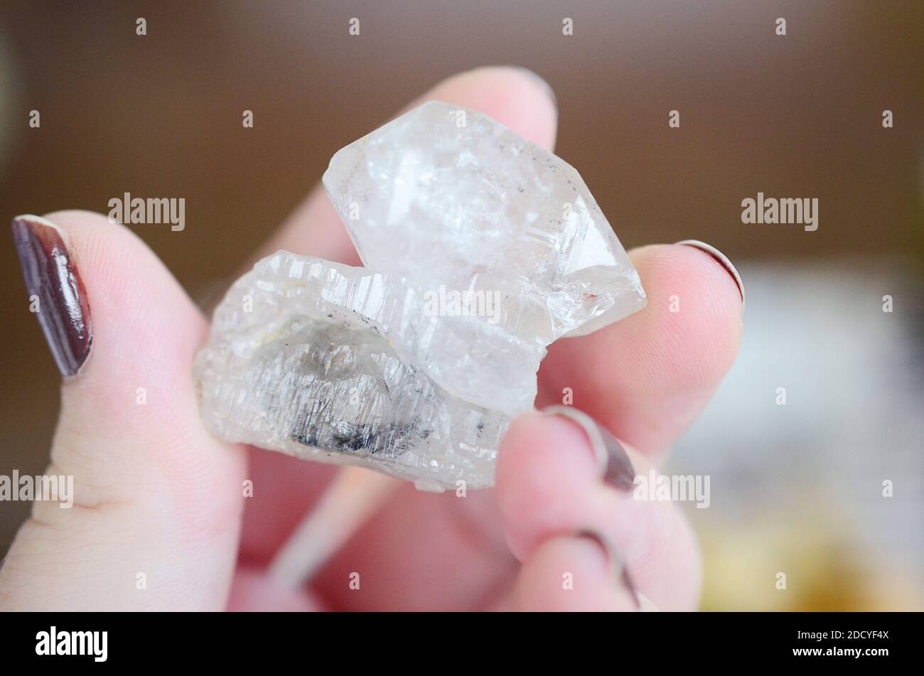 Clear quartz being held in woman's hand. Clear quartz point in the sunlight. Healing quartz with