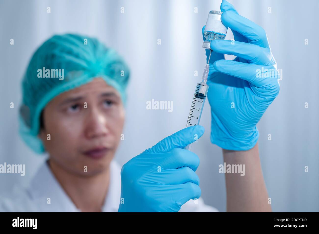 Doctor's hands fill syringe with medicine vial on hands of a nurse,doctor preparing administer injection to the patient. medicine concept Stock Photo