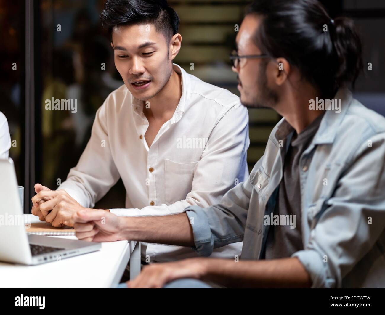Portrait of Asian businessman working late having meeting with business team to brainstorm idea at office meeting room. Work hard deadline and overtim Stock Photo