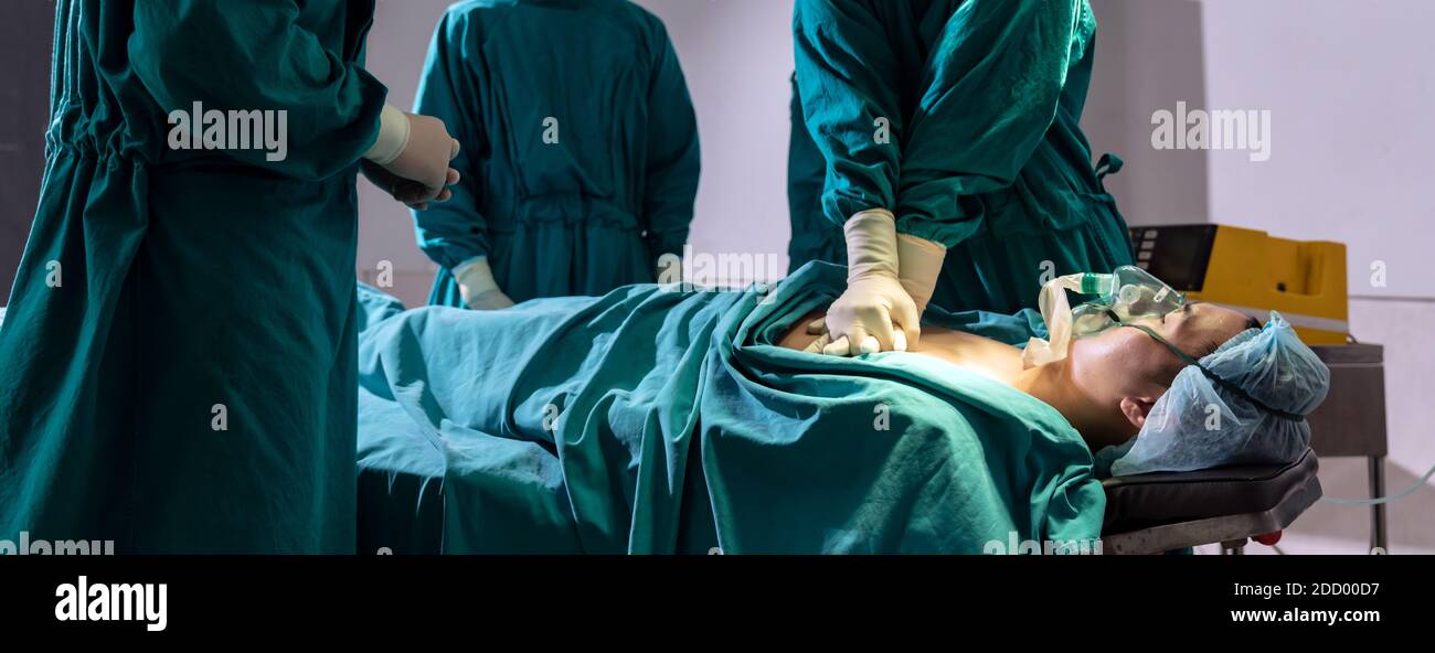 Panorama Surgeon doctor and nurse do CPR to patient while patient have problem with Sudden Cardiac Arrest while surgery in Operating Room OR. Medical Stock Photo