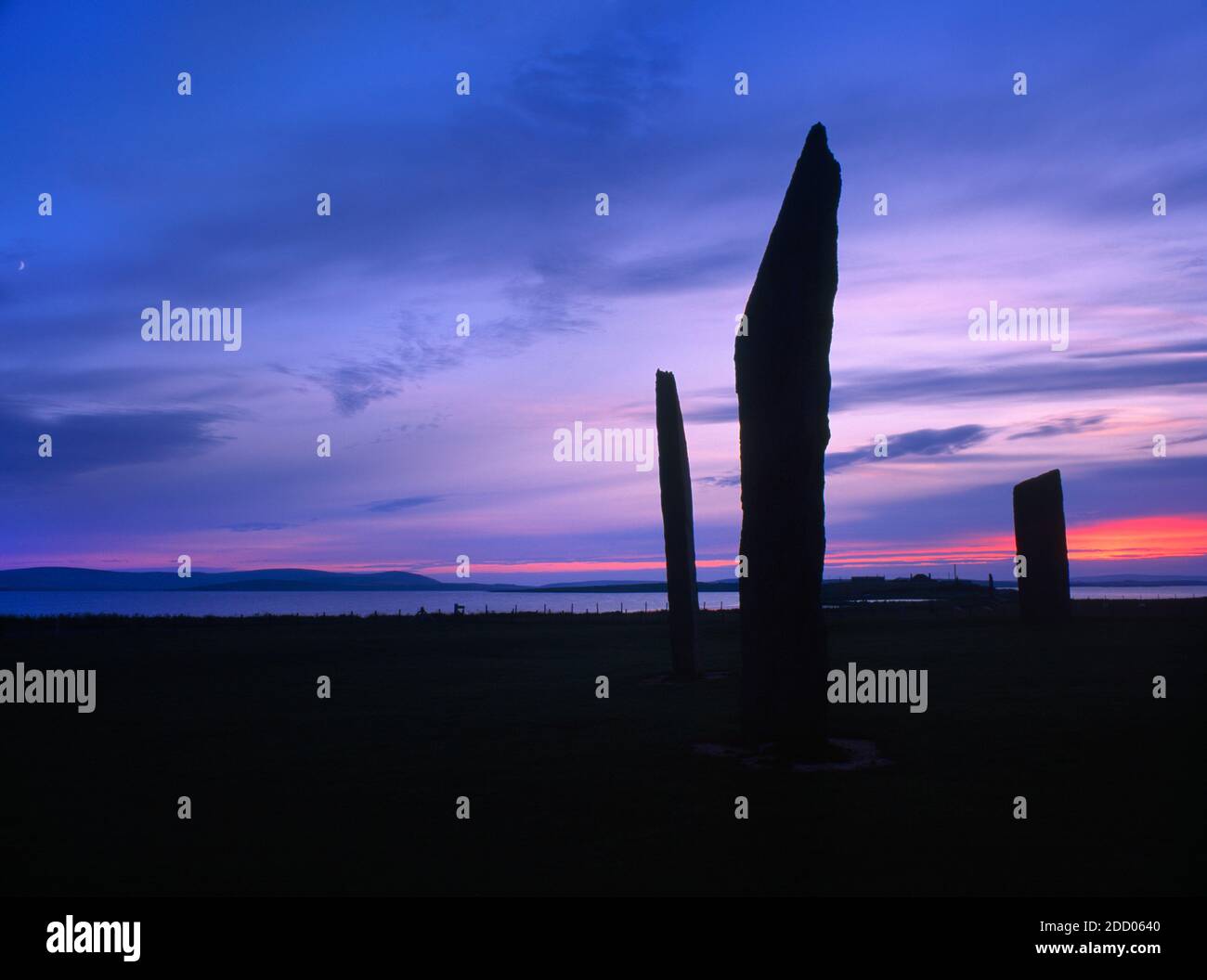 The three tallest slabs of the Stones of Stenness stone circle, Orkney, Scotland, UK, looking NW at 10-30pm after sunset with a rising moon extreme L. Stock Photo
