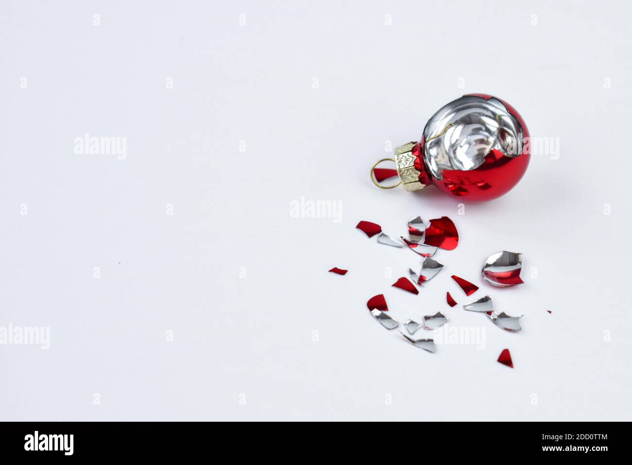 Broken Christmas ball in red on a white background. The view from the