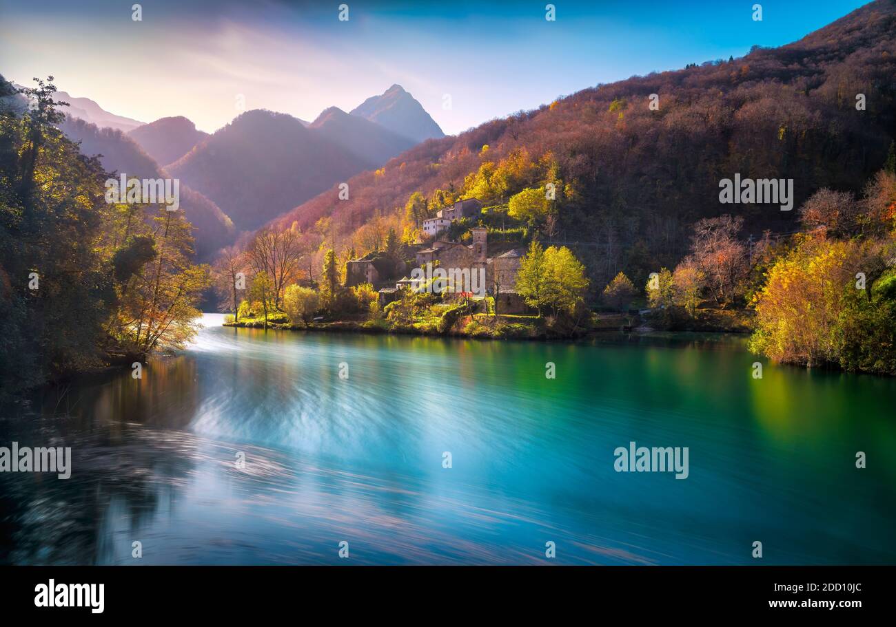 Isola Santa medieval village, lake and Alpi Apuane mountains in autumn foliage. Garfagnana, Tuscany, Italy Europe. Long exposure. Stock Photo