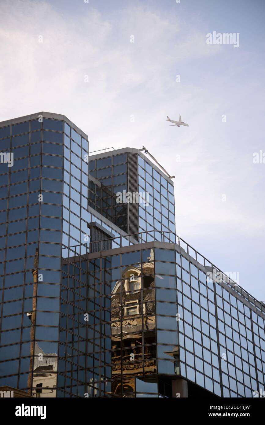 London scene with glass towers and overhead aeroplane Stock Photo