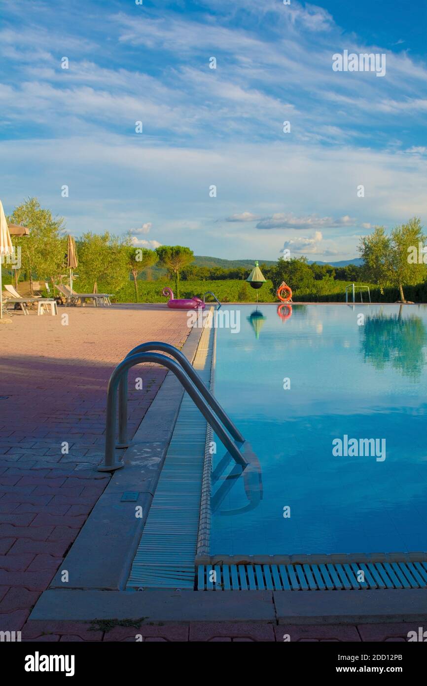 An empty hotel swimming pool in Tuscany, Italy, in the late afternoon sun Stock Photo