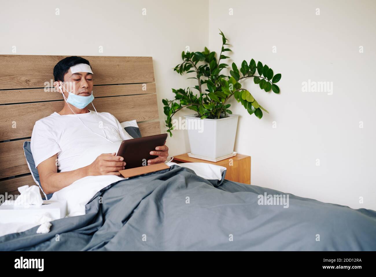 Sick man lying in bed Stock Photo