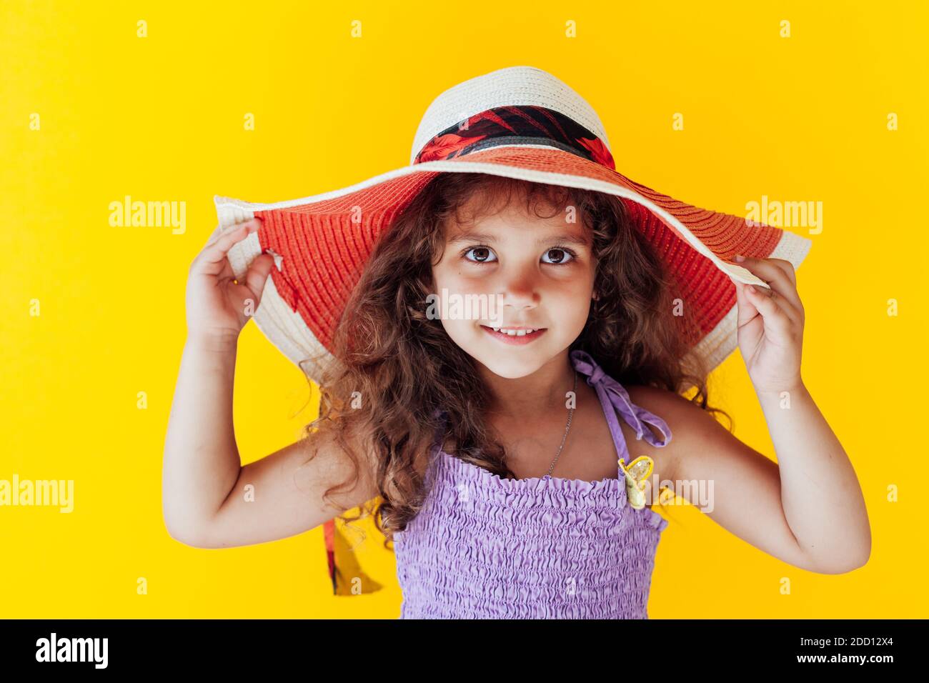 Little curly fashionable girl in a hat with fields Stock Photo