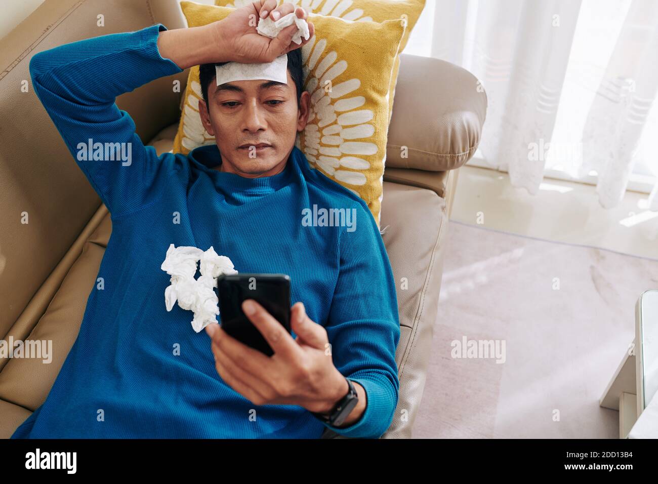 Sick man resting on sofa Stock Photo