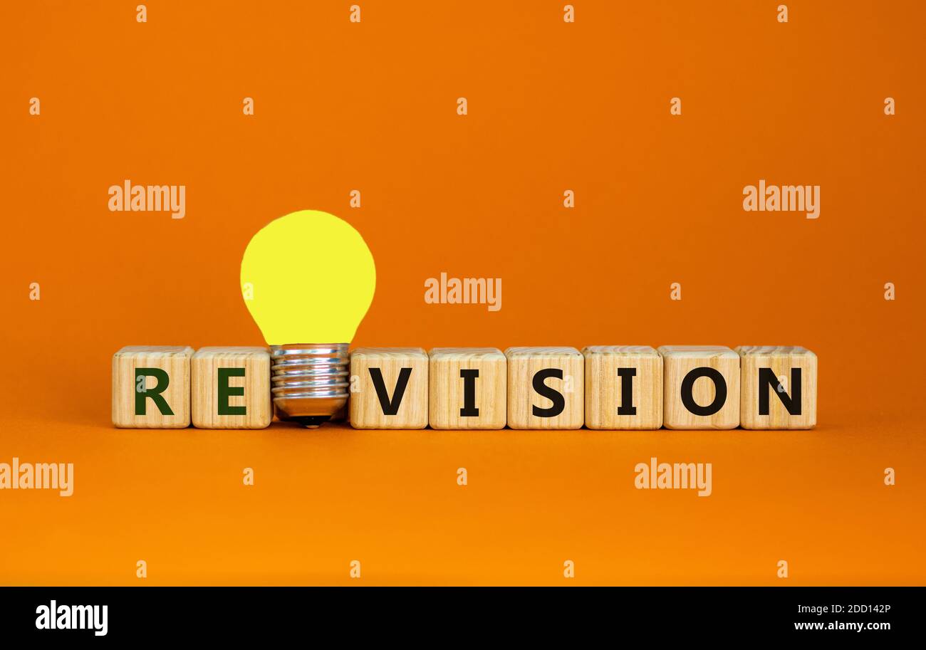 Wooden cubes with word 'revision'. Yellow light bulb. Beautiful orange background. Business and revision concept. Copy space. Stock Photo