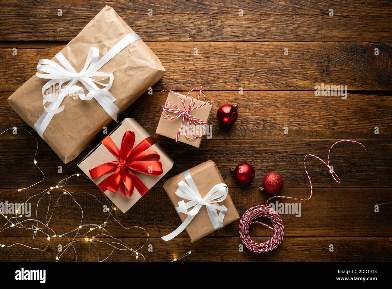 Christmas presents covered with craft paper on a wooden background, top view. Winter holidays concept Stock Photo