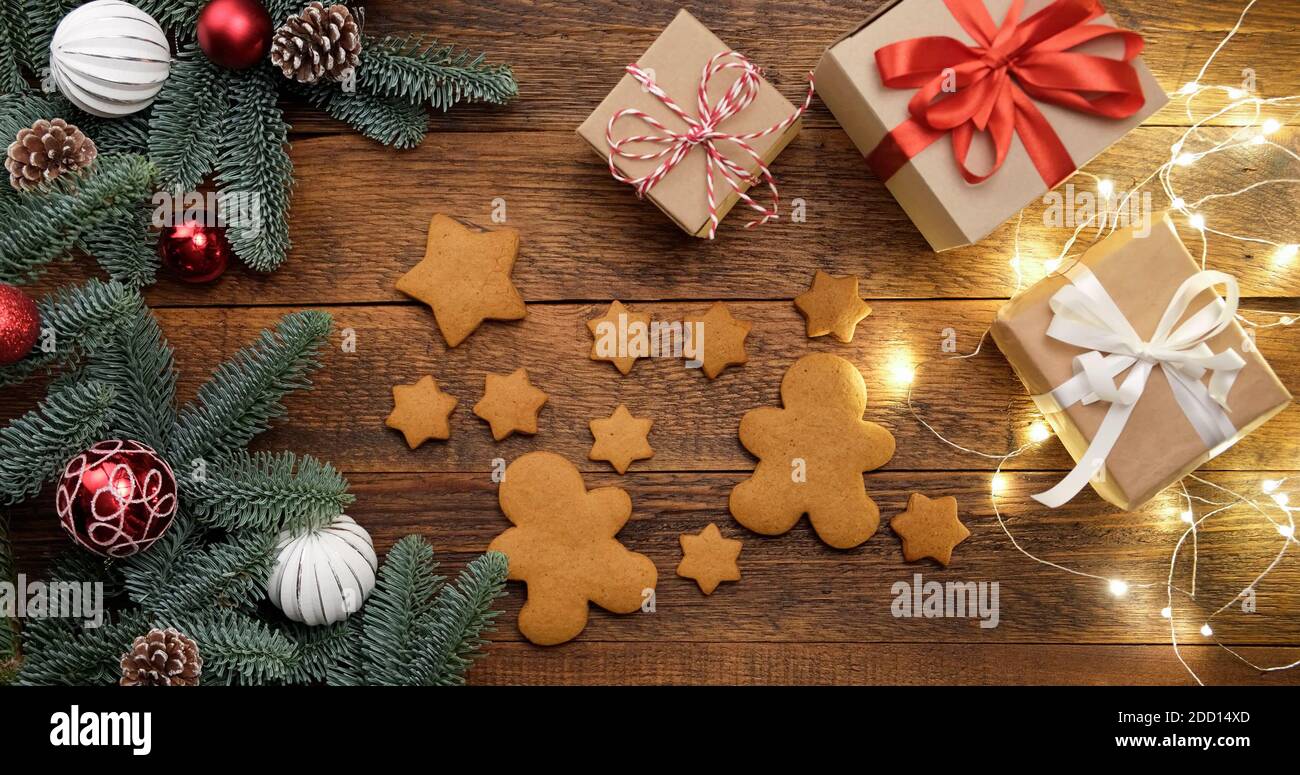 Gingerbread cookies, Christmas gifts, lights and fir tree. Christmas or New Year background Stock Photo