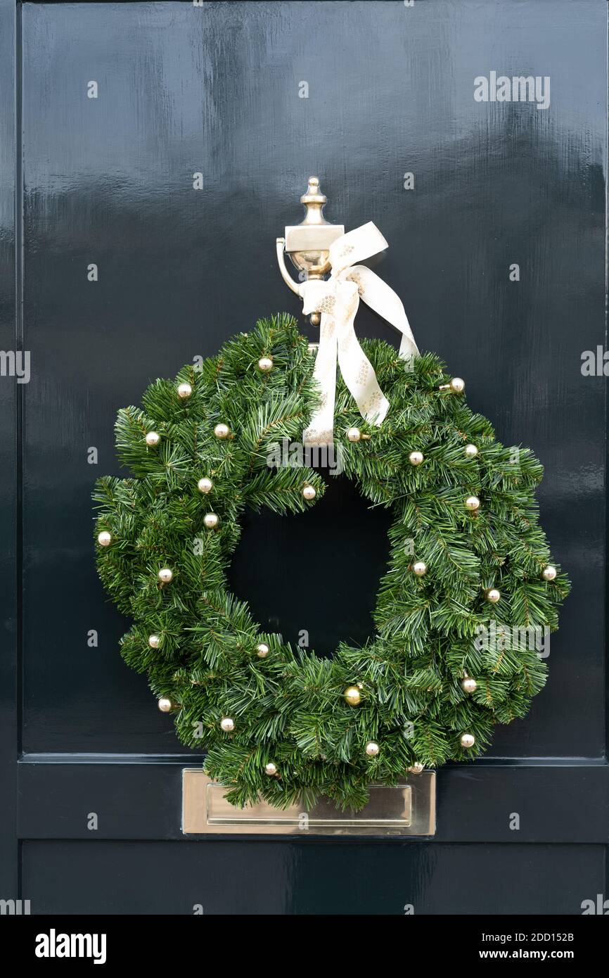 Beautiful door is decorated for Christmas with an evergreen wreath ...